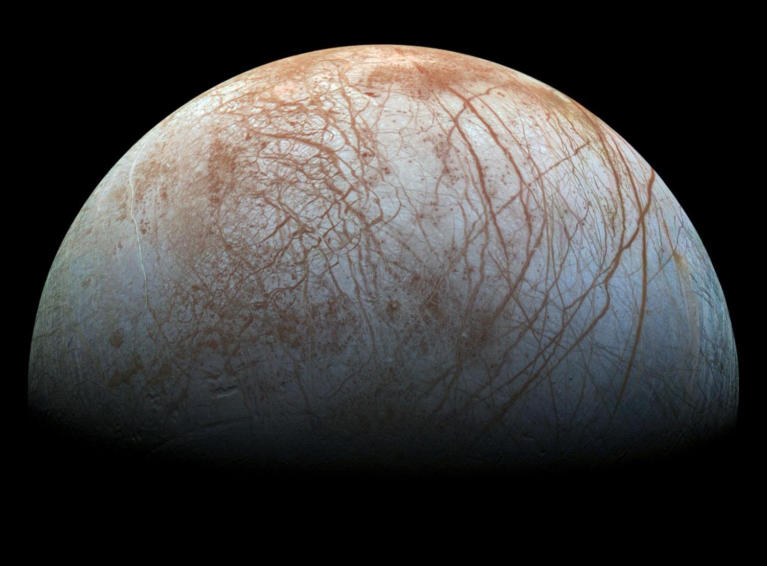 Jupiter's moon Europa, a pale disk crossed by reddish-brown cracks and streaks