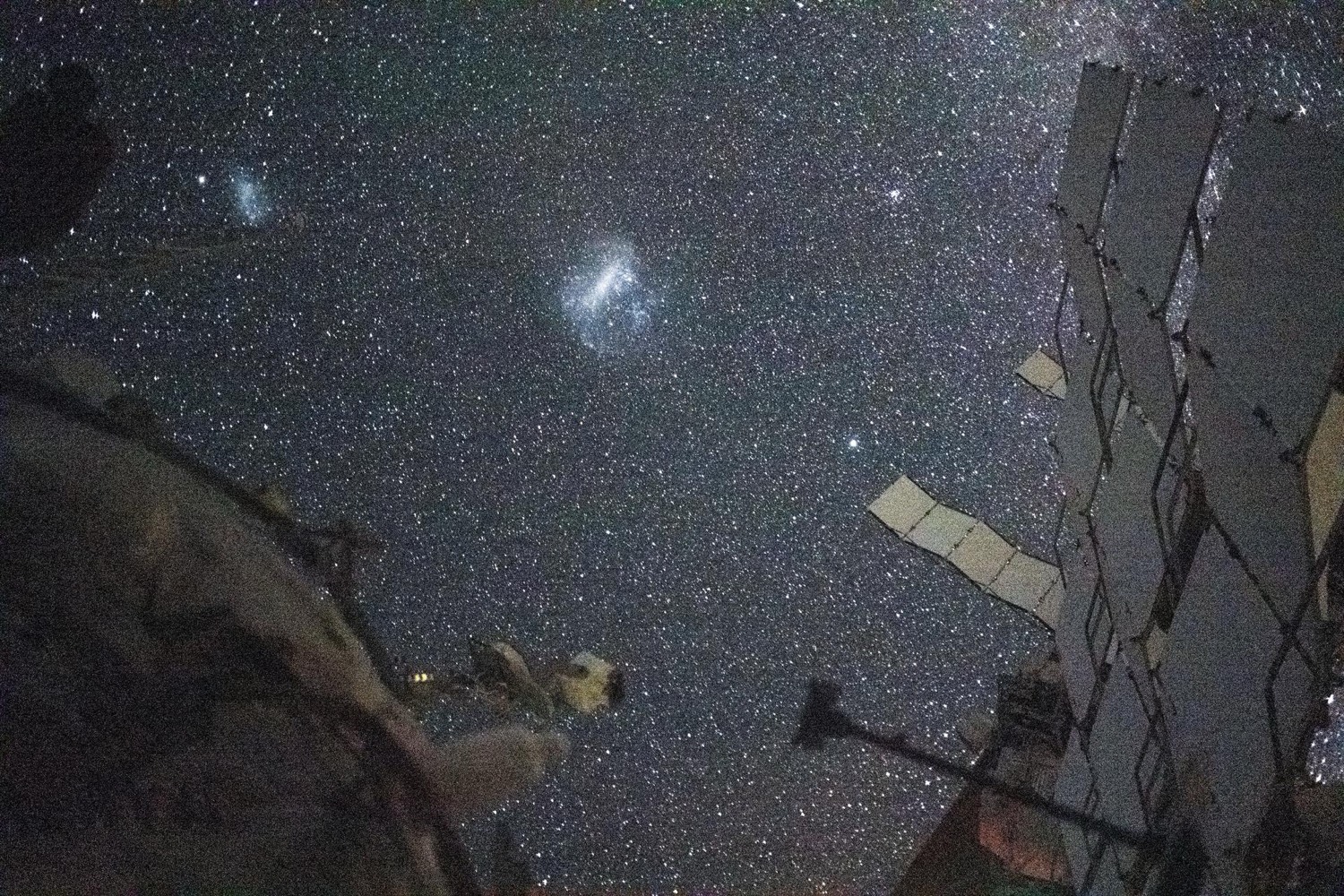 The Large and Small Magellanic Clouds above Earth's glowing atmosphere, photographed from orbit